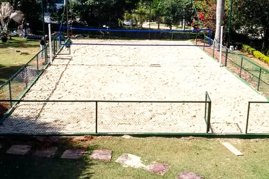 Foto do acervo da Pratika Sport: quadra de areia com rede e cercamento